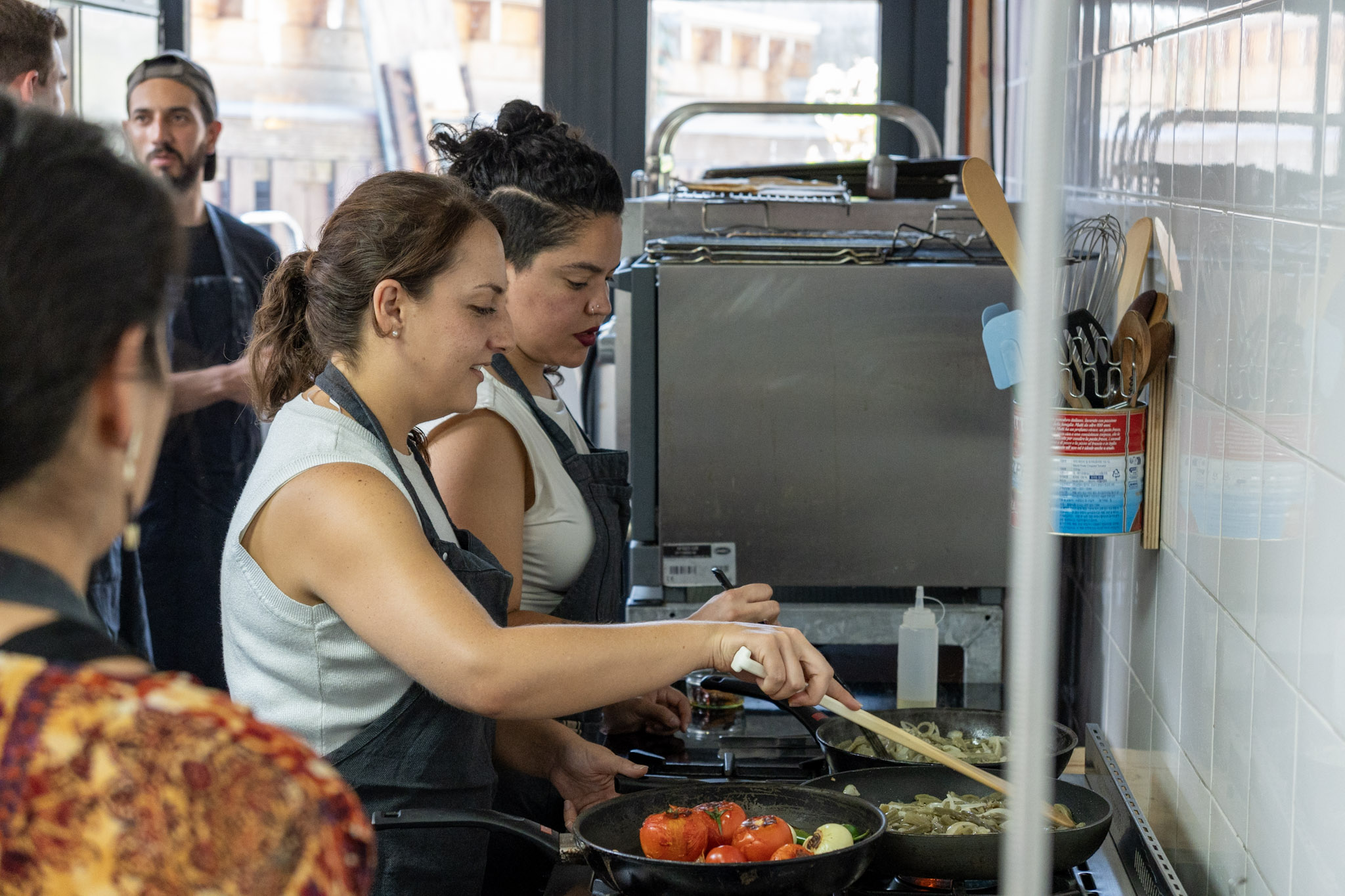Two guests cooking side by side at a Chilango Eats session